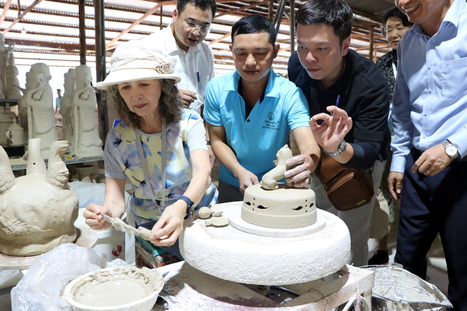 Experiencia práctica: los invitados aplican motivos decorativos en piezas sin esmaltar. (Foto: VNA)