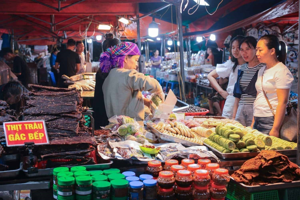 Los visitantes buscan adquirir especialidades locales de Lao Cai. Foto: VNA
