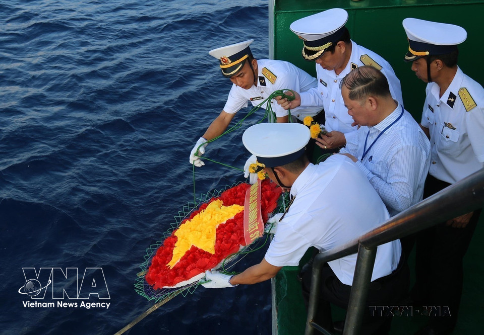 Oficiales y soldados depositan en el mar una corona floral con forma de la bandera nacional en homenaje a los mártires caídos en las aguas de Truong Sa (4 de junio de 2021). (Foto: VNA)
