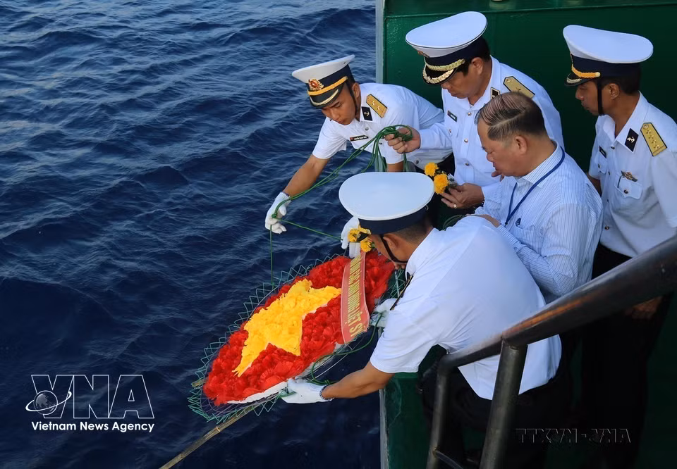 Oficiales y soldados depositan en el mar una corona floral con forma de la bandera nacional en homenaje a los mártires caídos en las aguas de Truong Sa (4 de junio de 2021). (Foto: VNA)