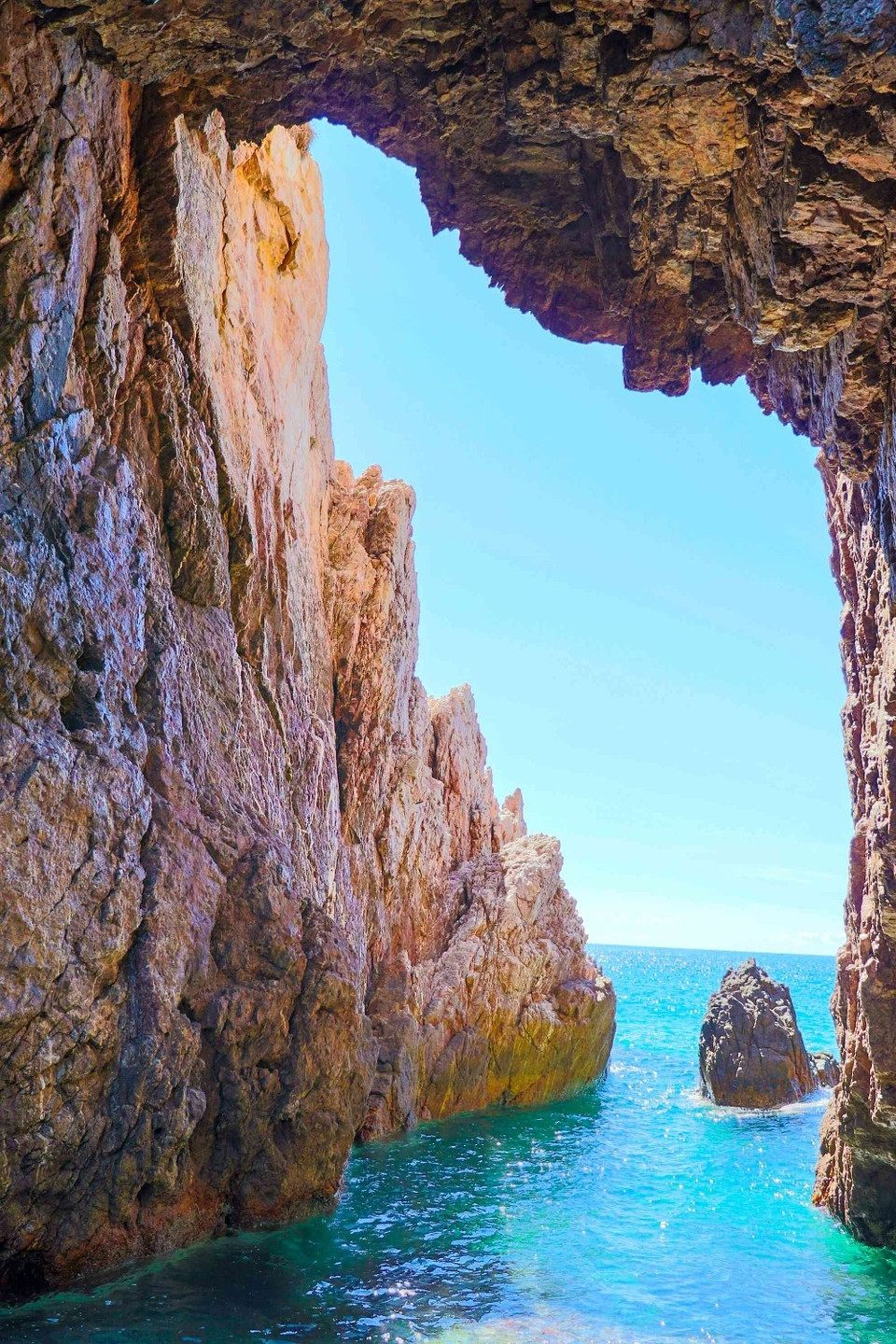 El cabo Vi Rong se proyecta imponente hacia el mar, con una presencia majestuosa. En medio de las rocas, una cueva se abre hacia el océano, formando una unión armoniosa entre la montaña y el mar. Foto: Autoridad Nacional de Turismo