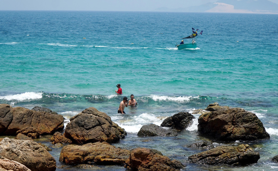 Los turistas disfrutan sumergiéndose en las aguas cristalinas cerca del cabo Vi Rong. Foto: VNA