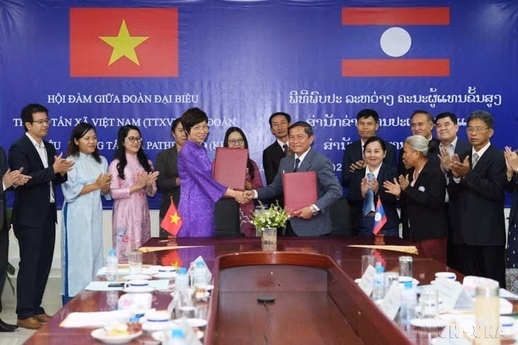 Vu Viet Trang, directora general de la Agencia Vietnamita de Noticias (VNA), y Vannasin Simmavong, director general de la Agencia de Noticias de Laos (KPL), intercambian el acta de cooperación (Vientiane, 20 de noviembre de 2024). Foto: VNA