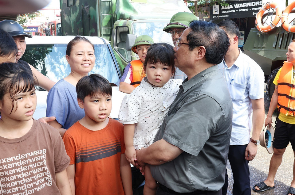 El primer ministro Pham Minh Chinh visita y brinda apoyo a las personas afectadas por las inundaciones en el barrio Phan Dinh Phung. (Foto: VNA)