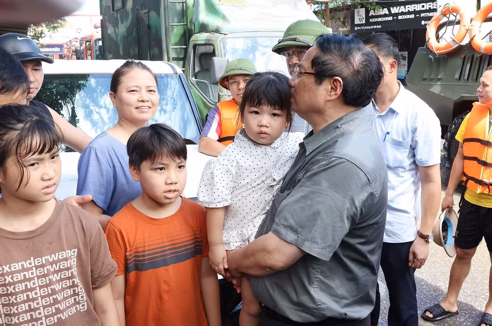 El primer ministro Pham Minh Chinh visita y brinda apoyo a las personas afectadas por las inundaciones en el barrio Phan Dinh Phung. (Foto: VNA)