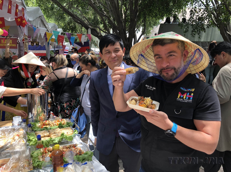 El alcalde del distrito Mauricio (México), Tabe Echartea, disfrutando de un rollito de primavera (Nem) vietnamita durante el Festival Cultural y Gastronómico Bazaar ASEAN+3, con motivo del 55.º aniversario de la fundación de la ASEAN (8 de agosto de 2022). Foto: VNA