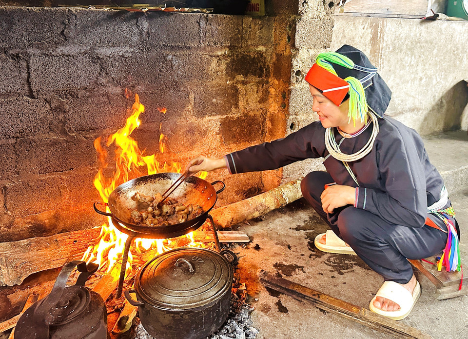 Junto al fuego, una mujer de la etnia Dao mantiene viva la rutina cotidiana en las casas ancestrales de Xa Phin. (Foto: VNA)