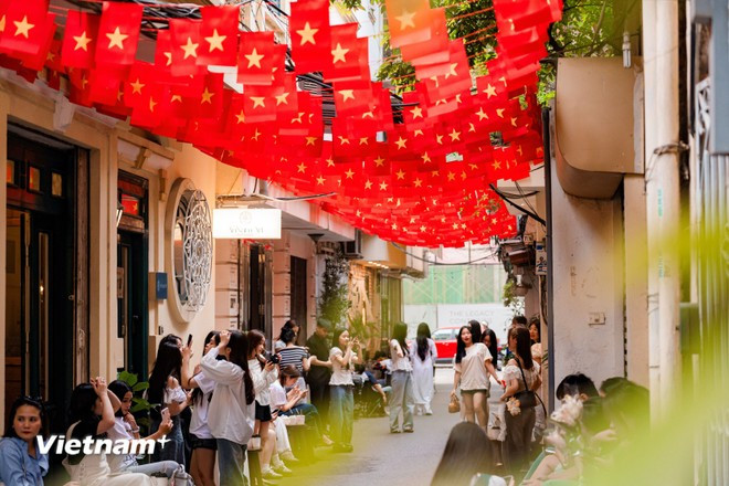 Además, los pequeños callejones, cubiertos de banderas, también se han convertido en lugares ideales para que los jóvenes hagan check-in. (Foto: Vietnam+)