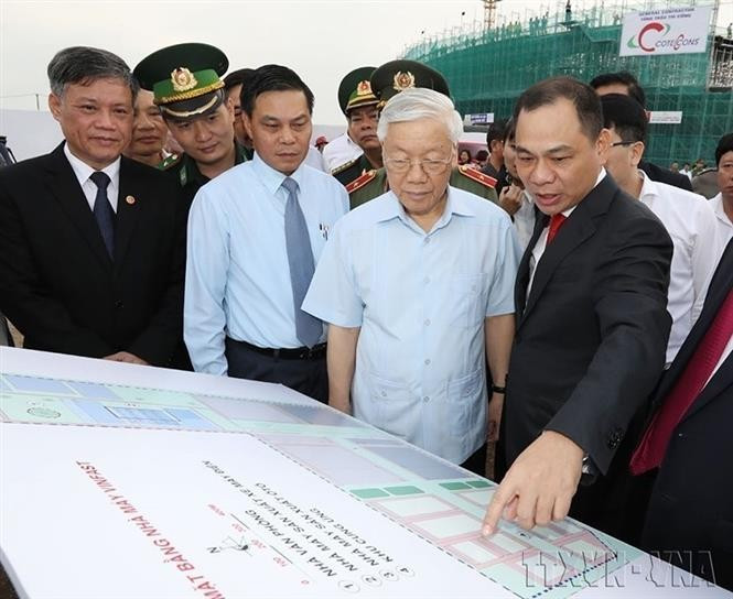 El empresario Pham Nhat Vuong, presidente del grupo Vingroup (derecha), muestra al secretario general del Partido, Nguyen Phu Trong, el plano de construcción de la planta de VINFAST en la ciudad de Hai Phong (14 de noviembre de 2017). Foto: VNA