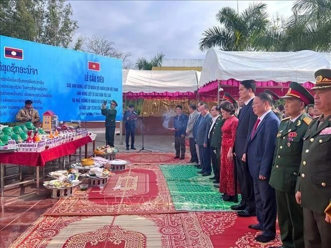 Delegados de Vietnam y Laos observan un minuto de silencio para conmemorar a los heroicos mártires de ambas naciones. (Foto: VNA)