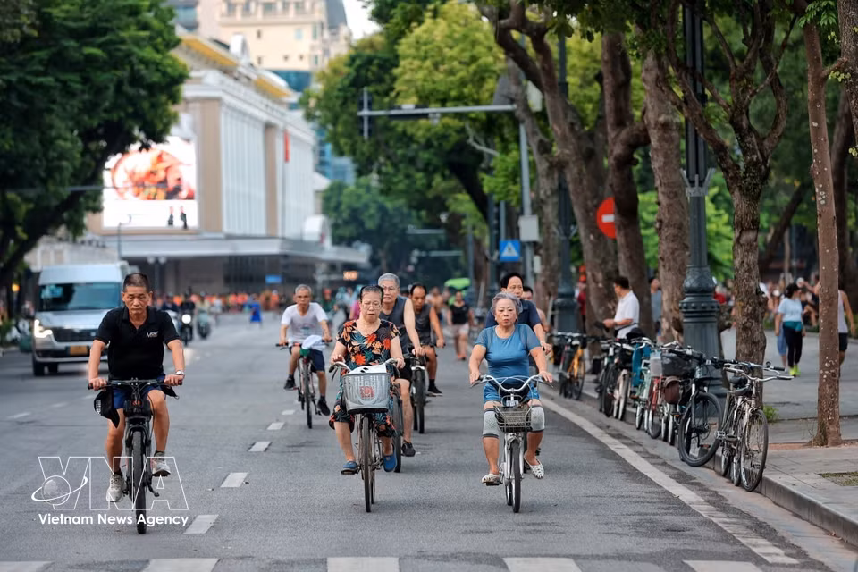 Personas mayores montan en bicicleta para hacer ejercicio por las calles alrededor del lago Hoan Kiem por la mañana. Foto: VNA