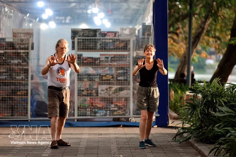 Turistas extranjeros de edad avanzada alojados en Vietnam comienzan el día haciendo ejercicio para mantenerse saludables. Foto: VNA