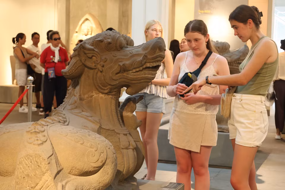Visitantes extranjeros exploran la estatua del monstruo acuático Makara en la cultura Cham. Foto: VNA