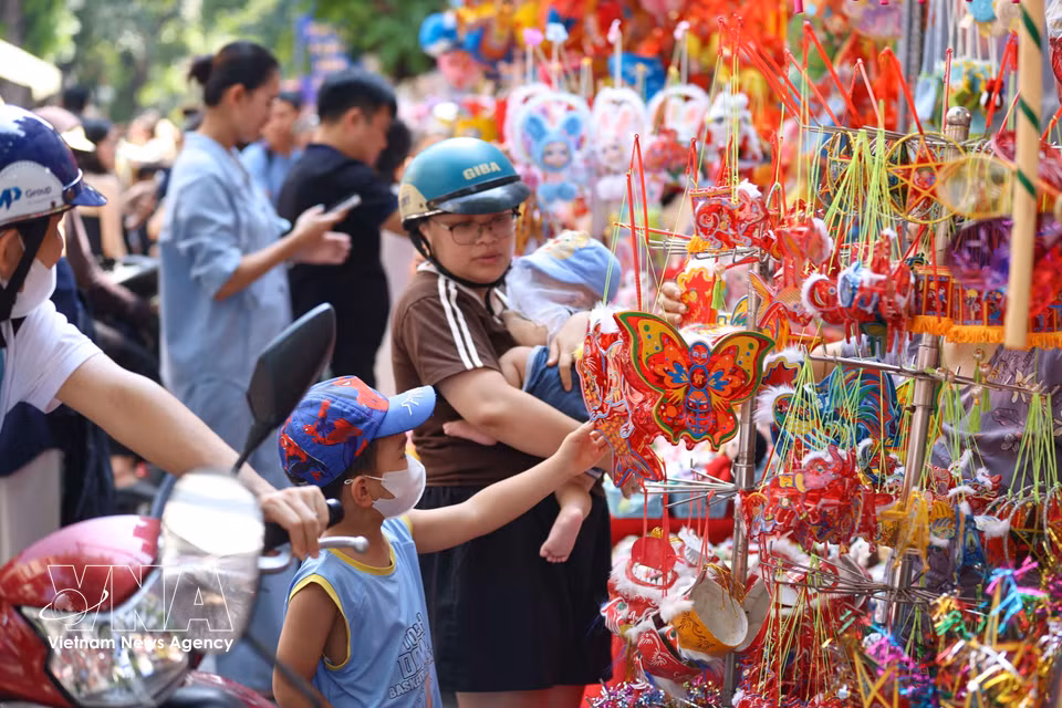 Los niños eligen sus juguetes favoritos como regalos para el Festival de Medio Otoño. Foto: VNA