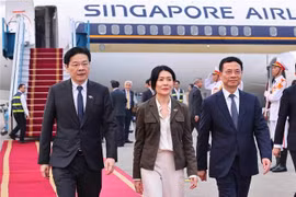 El ministro vietnamita de Ciencia y Tecnología, Nguyen Manh Hung, recibe al primer ministro de Singapur, Lawrence Wong, y su esposa en el aeropuerto de Noi Bai. (Fuente: VNA)