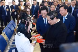 El primer ministro vietnamita, Pham Minh Chinh, entrega dinero de la suerte a los pasajeros en la estación de tren de Hanoi. (Fuente: VNA)