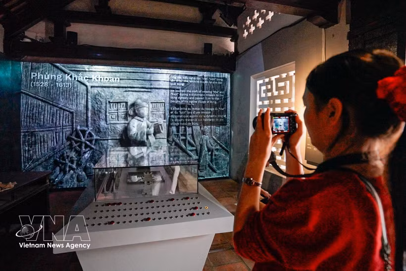 Los visitantes disfrutan de la exposición "La historia de la piedra preserva la memoria", que presenta un formato tradicional combinado con soluciones de tecnología digital (Foto: VNA)