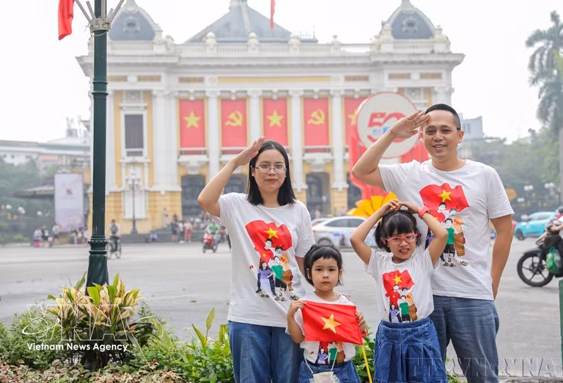 Una familia se toma una foto de recuerdo con motivo del 50.º aniversario de la liberación del sur de Vietnam y la reunificación nacional (30 de abril de 2025). (Foto: VNA)