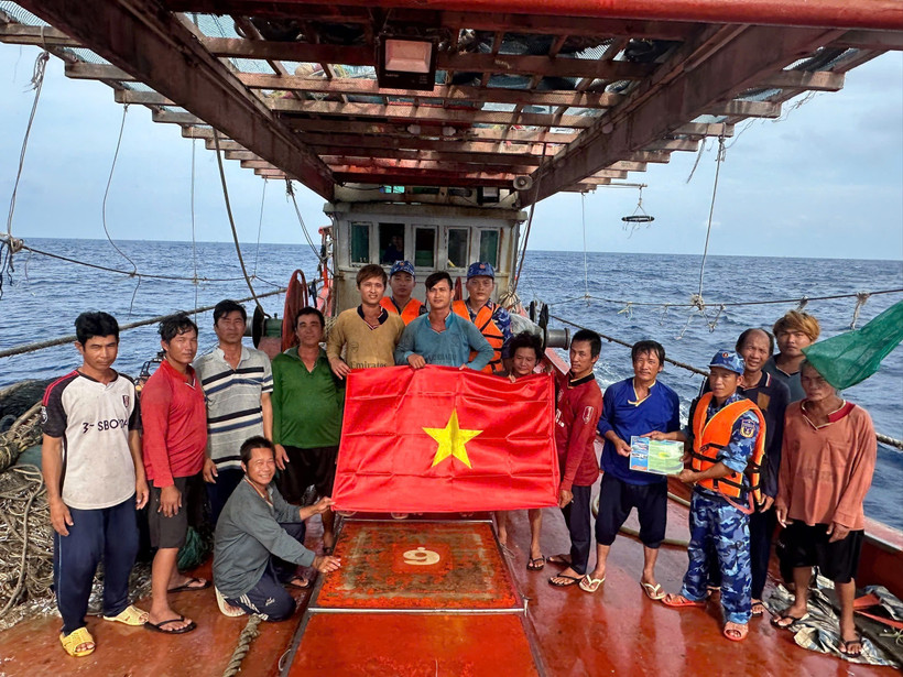 Las fuerzas de seguridad marítima de Ciudad Ho Chi Minh entregan la bandera nacional y difunden medidas preventivas contra la IUU a los pescadores (Foto: VNA)