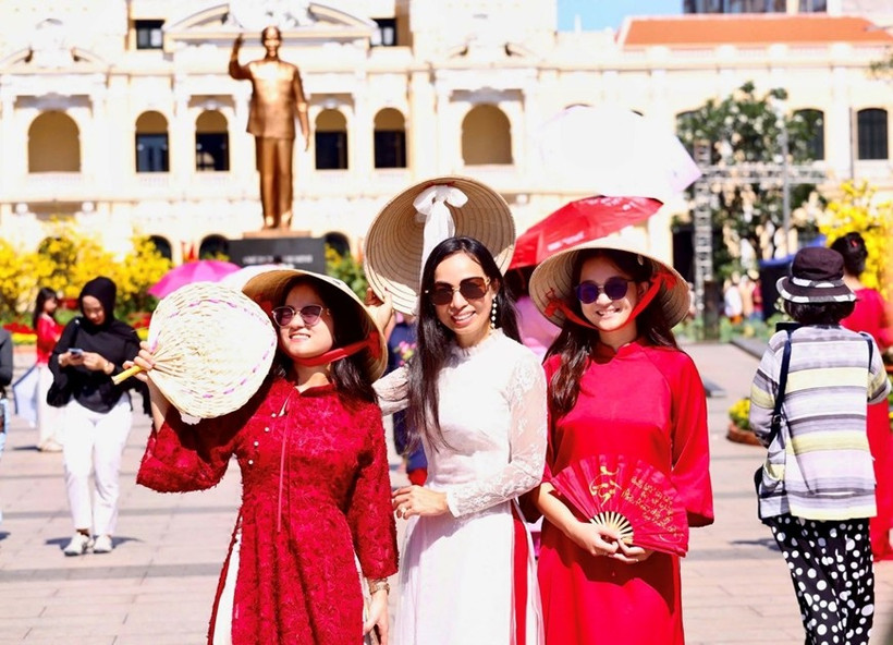 Vietnamitas que regresan del exterior exploran la calle de flores de Nguyen Hue. (Foto: qdnd.vn)