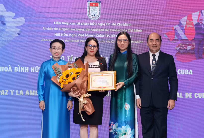 La cónsul general de Cuba en Ciudad Ho Chi Minh, Ariadne Feo Labrada (segunda a la izquierda), recibe la insignia “Por la paz y la amistad entre los pueblo” de la VUFO en el evento (Foto: VNA)
