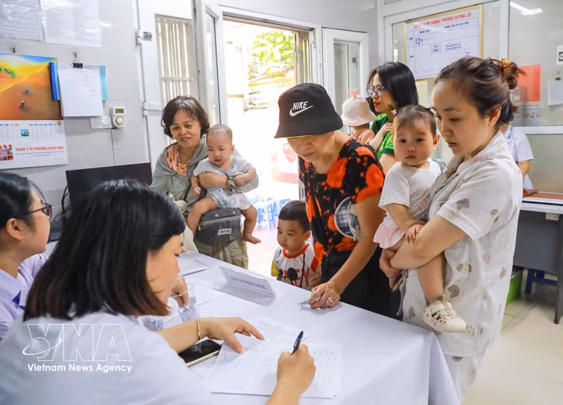 Las familias llevan a sus hijos a recibir vitamina A en la clínica del barrio de Bach Mai, en Hanoi. (Foto: VNA)