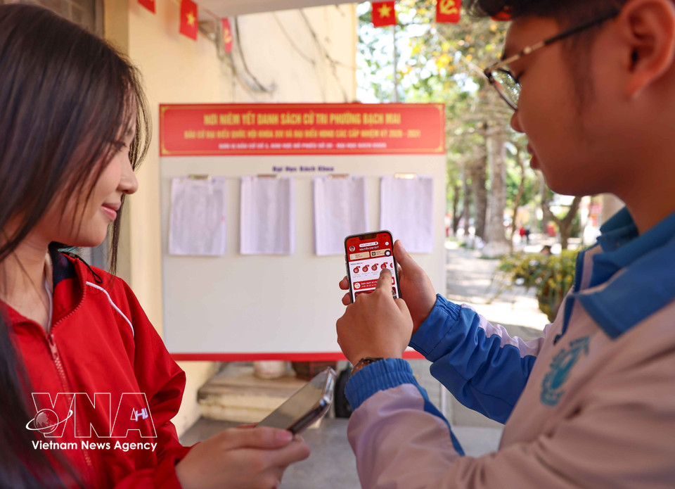 Votantes estudiantes de la Universidad de Ciencia y Tecnología de Hanoi consultan datos de los candidatos en la aplicación VNeID. Foto: VNA