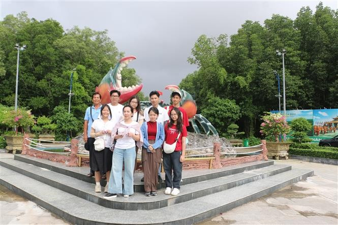 Visitantes toman fotos junto al símbolo del cangrejo en la Zona Turística del Cabo de Ca Mau. Foto: VNA