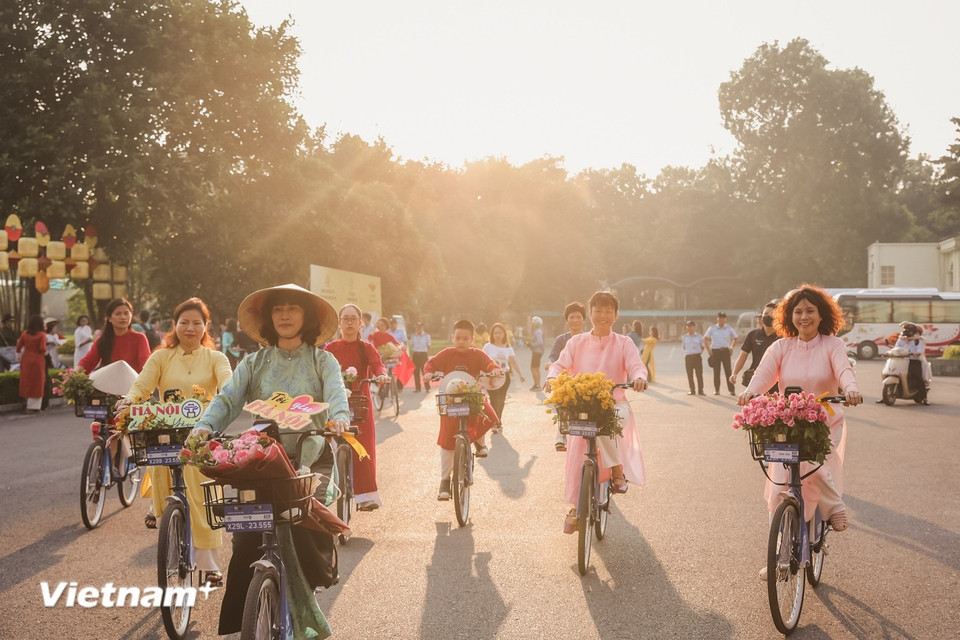 Las risas, el lento flujo de personas paseando en bicicleta por las calles, esbozan un Hanoi completamente diferente: sin prisas, sin ruidos, solo queda la belleza solemne, cálida y llena de nostalgia que, quien haya pasado una vez el Tet aquí, difícilmente podrá olvidar. (Foto: Vietnam+)