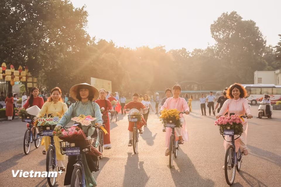 Las risas, el lento flujo de personas paseando en bicicleta por las calles, esbozan un Hanoi completamente diferente: sin prisas, sin ruidos, solo queda la belleza solemne, cálida y llena de nostalgia que, quien haya pasado una vez el Tet aquí, difícilmente podrá olvidar. (Foto: Vietnam+)