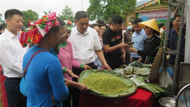 Dirigentes de la provincia de Lao Cai y residentes visitando los puestos de exhibición de productos de Com Hop Thanh. Foto: VNA