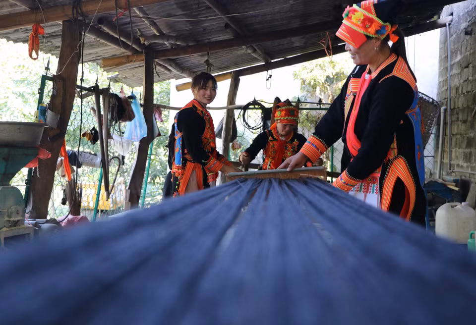 Brillantes hilos negros que forman el característico traje de las mujeres Dao. Foto: VNA