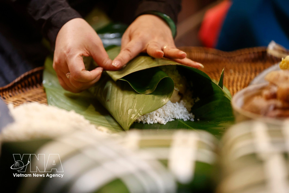 Se requiere de un par de manos habilidosas para envolver hermosos pasteles cuadrados en preparación para la tradicional festividad del Tet. (Foto: VNA)