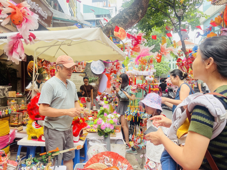 Niños acompañados por sus padres visitan la calle capitalina de Hang Ma para comprar juguetes del Festival de Medio Otoño. Foto: VNA