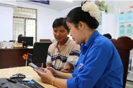 Una jóven de la Unión de Jóvenes Comunistas Ho Chi Minh de la comuna de Tuy An Nam, provincia de Dak Lak, orienta a los residentes sobre cómo completar la información correctamente antes de presentar los documentos para trámites administrativos. Foto: VNA