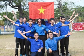 Miembros de la Unión de Jóvenes Comunistas Ho Chi Minh en Cuba izan la bandera nacional. Foto: VNA
