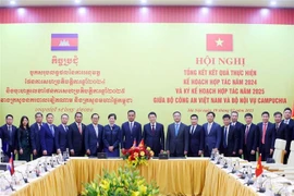 El general Luong Tam Quang, ministro de Seguridad Pública de Vietnam, el viceprimer ministro y titular de Interior de Camboya, Sar Sokha. y los delegados toman fotografía. (Fuente: VNA)