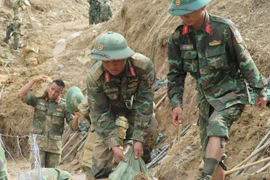 Oficiales y soldados realizan trabajos para abrir caminos a aldeas aisladas por las inundaciones en la comuna de Ngoc Linh. (Foto: VNA)