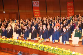 Los delegados realizan la ceremonia de izamiento de la bandera durante la conmemoración. (Foto: VNA)