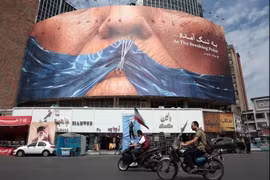 El 2 de mayo de 2026, varios automovilistas pasaron junto a una valla publicitaria antiestadounidense que hacía referencia al presidente Donald Trump y al estrecho de Ormuz en la plaza Valiasr de Teherán. (Foto: AFP)