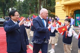 El primer ministro de Vietnam, Pham Minh Chinh, y su homólogo neozelandés, Christopher Luxon, con los estudiantes de Hanoi. (Fuente: VNA)