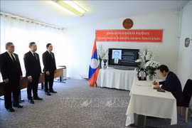 El embajador Mai Phan Dung, jefe de la misión permanente de Vietnam en Ginebra, firma el libro de condolencias en la sede de la misión de Laos. (Fuente: VNA)