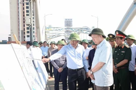 El secretario general del Partido Comunista de Vietnam, To Lam, escucha el informe del líder de la provincia de Thai Nguyen sobre las labores para superar las consecuencias de la tormenta y las inundaciones en el puente Ben Tuong. (Foto: VNA)