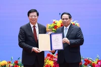 Qiu Yong (izquierda), secretario del Comité del Partido Comunista de China en la Universidad de Tsinghua, entrega el título de "Profesor Honorario" al primer ministro Pham Minh Chinh. (Foto: VNA)