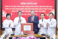 El secretario general del Partido Comunista de Vietnam, To Lam, regala un obsequio a funcionarios y personal médico del Hospital de la Amistad. (Foto: VNA)
