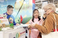 Turistas franceses estudian sobre destinos vietnamitas en la 49ª Feria Mundial de Turismo celebrada en París (Foto: VNA).