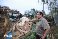 El primer ministro Pham Minh Chinh visita una casa completamente derrumbada debido a las inundaciones en la aldea de Phu Huu, comuna de Hoa Thinh, provincia de Dak Lak. (Foto: VNA)