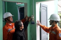 El personal eléctrico instruye a los residentes sobre el uso de equipos eléctricos al mudarse a sus nuevos hogares. (Foto: VNA)