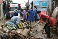 Las fuerzas armadas ayudan a los pobladores a limpiar las calles (Foto: VNA)