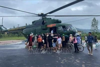 Un helicóptero militar lanza suministros de socorro a una zona afectada por las inundaciones. (Foto: VNA)